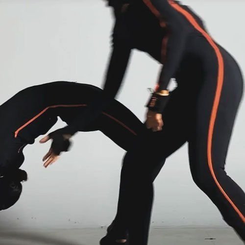 Deux performeurs en combinaison de motion capture répètent un mouvement