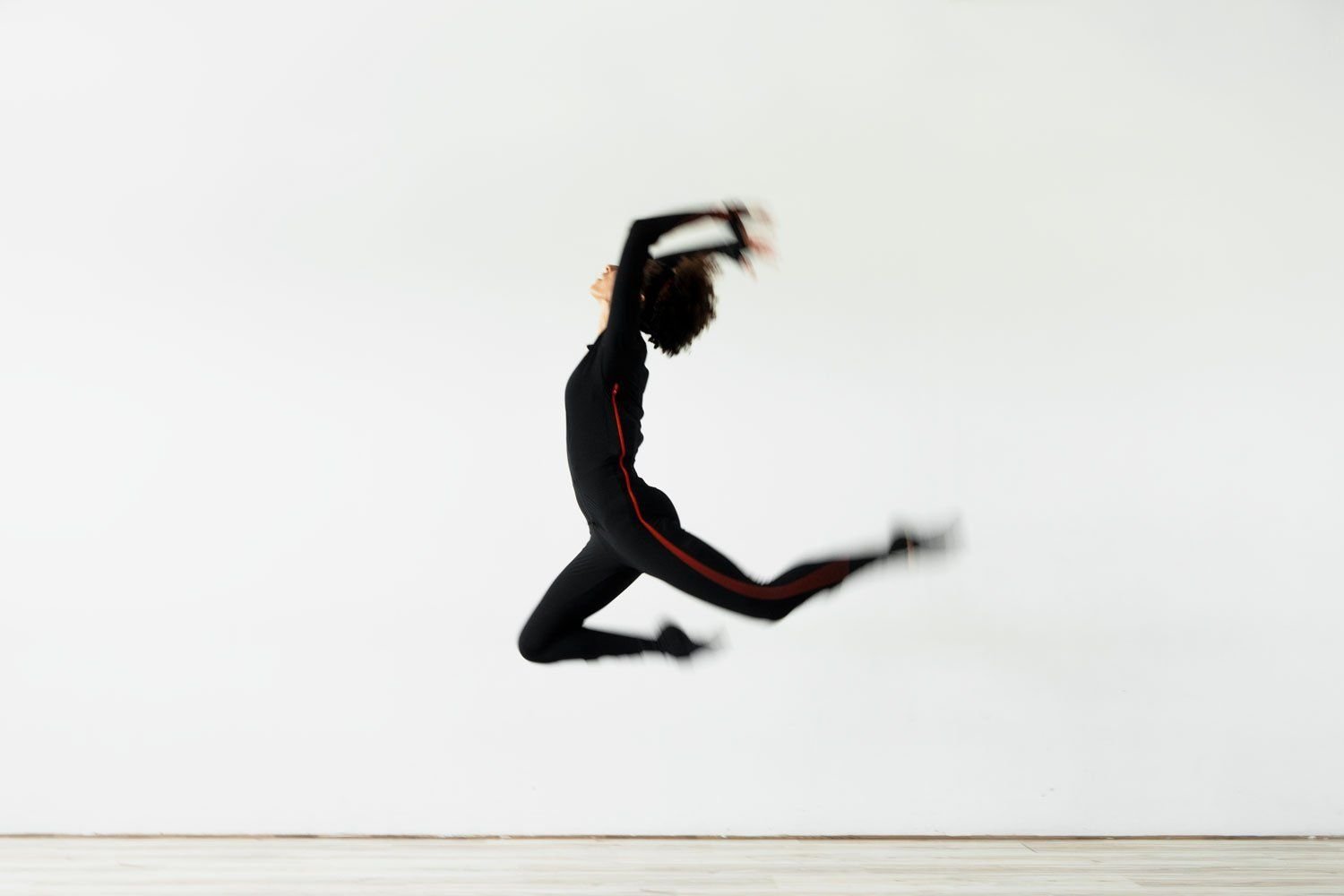 Une danseuse en combinaison de motion capture en plein saut